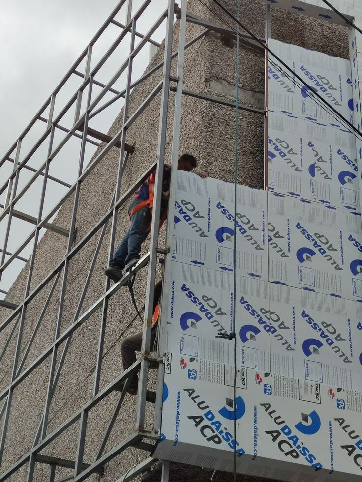 Équipe posant des panneaux Alucobond en hauteur